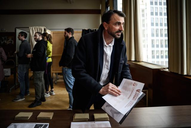 Incumbent mayor of Lyon and Europe-Ecology The Greens (EELV) party candidate for re-election Gregory Doucet picks up ballots before casting his vote during the second round of France's 2026 municipal elections in Lyon, central eastern France on March 22, 2026. (Photo by JEFF PACHOUD / AFP)
