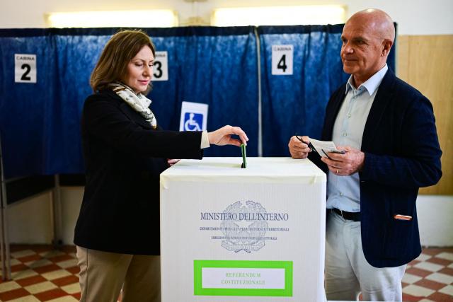 A woman casts her ballot in a polling station on the first day to vote for the Italian constitutional referendum on justice reform, in Milan, on March 22, 2026. (Photo by Piero CRUCIATTI / AFP)