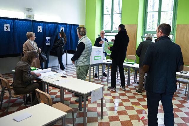 People wait in line to cast their ballot in a polling station on the first day to vote for the Italian constitutional referendum on justice reform, in Milan, on March 22, 2026. (Photo by Piero CRUCIATTI / AFP)