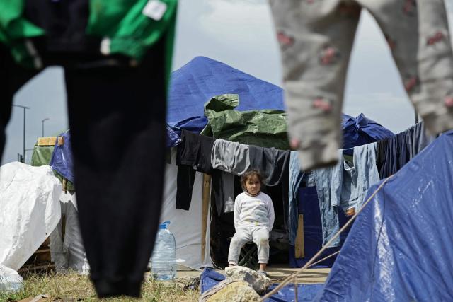 TOPSHOT - A displaced girl sits outside her tent at a parking lot in Beirut's waterfront area, on March 22, 2026. The Israeli military said it launched a wave of strikes on Beirut targeting the Iran-backed militant group Hezbollah, after urging residents of several areas to evacuate. Lebanon was pulled into the Middle East war when Hezbollah began firing rockets into Israel on March 2 to avenge the killing of Iran's supreme leader Ayatollah Ali Khamenei in US-Israeli strikes. Lebanon's health ministry says the latest war has killed more than 1,000 people in Lebanon and displaced more than one million more. (Photo by ibrahim AMRO / AFP)