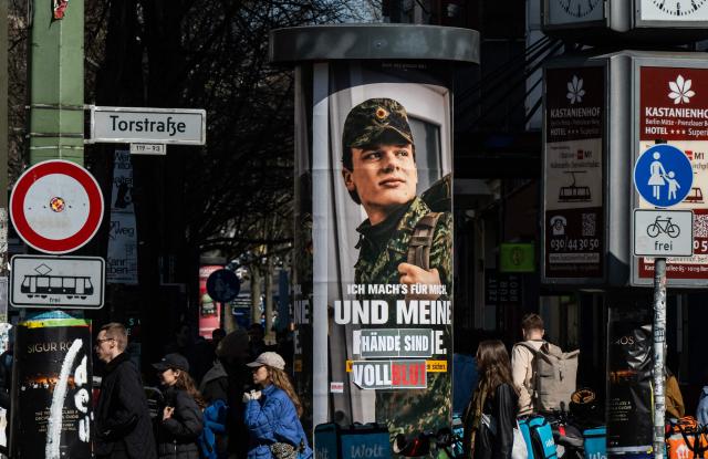An advertising poster for the German armed forces (Bundeswehr) is altered to read: "...and my hands are covered in blood", in Berlin on March 22, 2026. (Photo by John MACDOUGALL / AFP)
