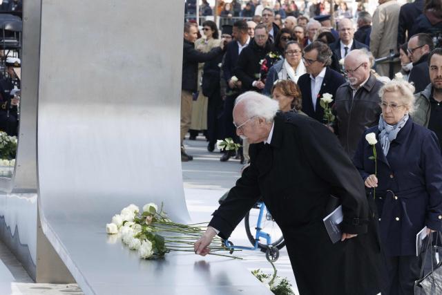 Attendees lay down flowers during a commemoration ceremony for the March 2016 terror attacks at the memorial monument on Rue de la Loi (Wetstraat) in Brussels on March 22, 2026. Belgium is marking the tenth anniversary of the 2016 jihadist bombings in Brussels, a trauma that still scars the country and that authorities say sharpened focus on intelligence and counterterrorism. (Photo by NICOLAS MAETERLINCK / Belga / AFP) / Belgium OUT
