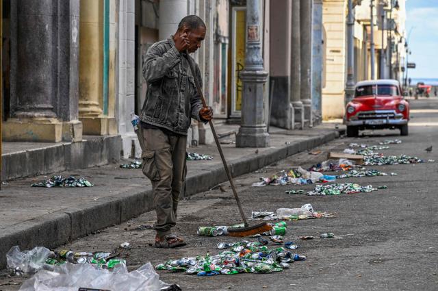 A man sweeps a street during a national blackout in Havana on March 22, 2026. A power outage struck the entire island of Cuba on March 21 the energy ministry said, in the second nationwide blackout in less than a week as its grid struggles under a US oil blockade. (Photo by YAMIL LAGE / AFP)