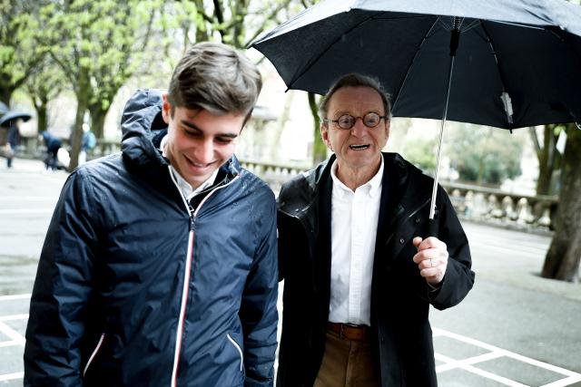Former Mayor of Grenoble and right-wing Les Republicains (LR) party candidate for his re-election Alain Carignon arrives with an umbrella at a polling station during the second round of France's 2026 municipal elections in Grenoble, central France on March 22, 2026. (Photo by Maxime Gruss / AFP)