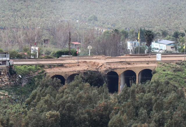 The damaged Qasmiyeh bridge located on a main highway linking villages in the Tyre district with others further north, following an Israeli airstrike in southern Lebanon on March 22, 2026. Israel's military struck a key bridge in south Lebanon on Sunday, an AFP correspondent said, after Israel's defence minister said the army had been ordered to destroy more bridges over the Litani River. Lebanon was drawn into the Middle East war on March 2, when pro-Iran Hezbollah launched rockets towards Israel in response to US-Israeli strikes that killed Iranian supreme leader on February 28, 2026. (Photo by Kawnat HAJU / AFP) / 