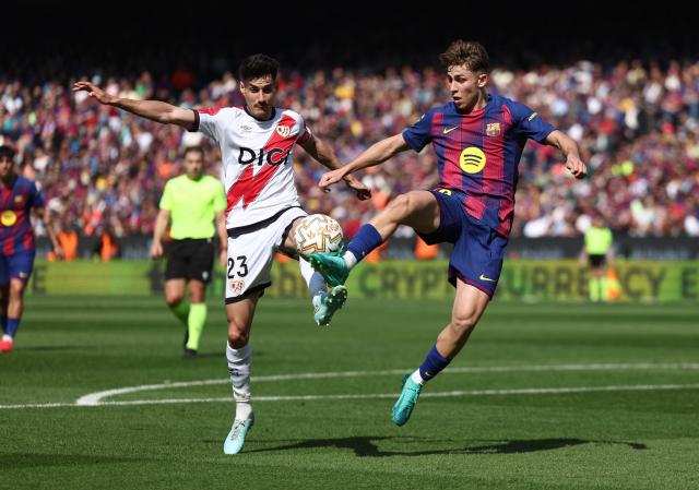 Rayo Vallecano's Spanish midfielder #23 Oscar Valentin fights for the ball with Barcelona's Spanish midfielder #16 Fermin Lopez during the Spanish league football match between FC Barcelona and Rayo Vallecano de Madrid at Camp Nou Stadium in Barcelona on March 22, 2026. (Photo by Josep LAGO / AFP)