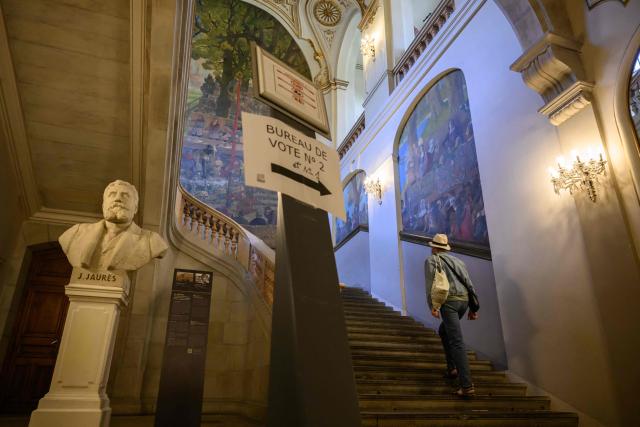 A local resident arrives to cast their ballot at a polling station during the second round of France's 2026 municipal elections in Toulouse, south-western France on March 22, 2026. (Photo by Ed JONES / AFP)