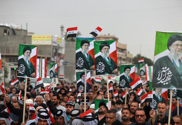 Waving the Iraqi flag and holding up placards with the image of the assassinated Iranian supreme leader Ayatollah Ali Khamenei, Iraqis rally in support of neighbouring Iran, in the al-Aamil district of Baghdad on March 22, 2026. On February 28, Israel and the United States launched strikes on Iran killing its supreme leader and triggering a war that spread across the Middle East and unleashed chaos across global markets and sent oil prices soaring. (Photo by Murtaja LATEEF / AFP) / 
