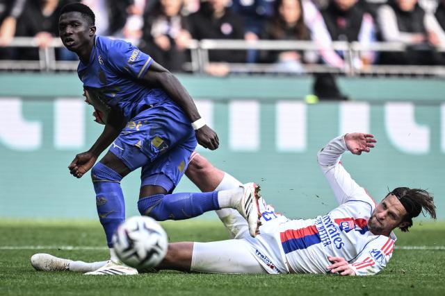 Monaco’s Swiss midfielder #06 Denis Zakaria (L) is tackled by Lyon’s Dutch Defender #33  Hans Hateboer (R) during the French L1 football match between Olympique Lyonnais (OL) and AS Monaco (ASM) at the Groupama Stadium in Decines-Charpieu, central-eastern France on March 22, 2026. (Photo by JEFF PACHOUD / AFP)