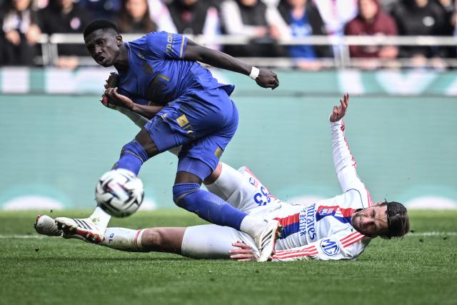 TOPSHOT - Monaco’s Swiss midfielder #06 Denis Zakaria (L) is tackled by Lyon’s Dutch Defender #33  Hans Hateboer (R) during the French L1 football match between Olympique Lyonnais (OL) and AS Monaco (ASM) at the Groupama Stadium in Decines-Charpieu, central-eastern France on March 22, 2026. (Photo by JEFF PACHOUD / AFP)