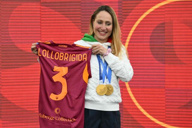 Italian athlete Francesca Lollobrigida poses with her Milano Cortina 2026 Olympic Games gold medals for 3.000m and 5.000m in speed skating before the Italian Serie A football match between AS Roma and Lecce at the Olympic Stadium in Rome on March 22, 2026. (Photo by Alberto PIZZOLI / AFP)