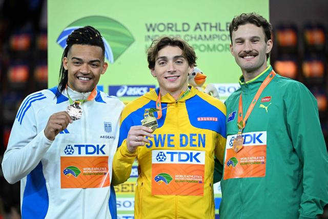 (LtoR) Silver medallist Greece's Emmanouil Karalis, gold medallist Sweden's Armand Duplantis and bronze medallist Australia's Kurtis Marschall celebrate on the podium for the men's pole vault event during the World Athletics Indoor Championships Kujawy Pomorze 2026 in Torun, Poland on March 22, 2026. (Photo by Kirill KUDRYAVTSEV / AFP)