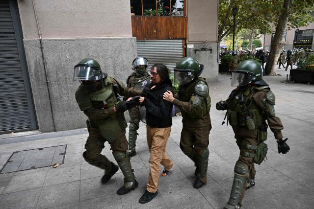 Riot police officers detain a protester during a demonstration on World Water Day amid President Jose Antonio Kast's plans to roll back environmental protections in Santiago on March 22, 2026. (Photo by RODRIGO ARANGUA / AFP)