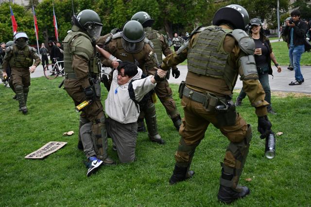 Riot police officers detain a protester during a demonstration on World Water Day amid President Jose Antonio Kast's plans to roll back environmental protections in Santiago on March 22, 2026. (Photo by RODRIGO ARANGUA / AFP)