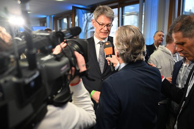 German Transport Minister Patrick Schnieder (C), brother of the conservative CDU party's top candidate for state elections in Rhineland-Palatinate Gordon Schnieder (not in picture), gives an interview on March 22, 2026 at the regional parliament in Mainz, southwestern Germany, as first exit polls of Rhineland-Palatinate's state elections are being released. German Chancellor Friedrich Merz's conservative CDU party ousted the centre-left Social Democratic Party on Sunday in a closely watched state election in which the far right also made big gains, according to exit polls. The CDU took around 30 percent of the vote to win the western state of Rhineland-Palatinate away from the SPD after 35 years, while the far-right Alternative for Germany party (AfD) looked set for a record score in western Germany, with around 20 percent, according to two public TV networks' exit polls. (Photo by DANIEL PETER / AFP)