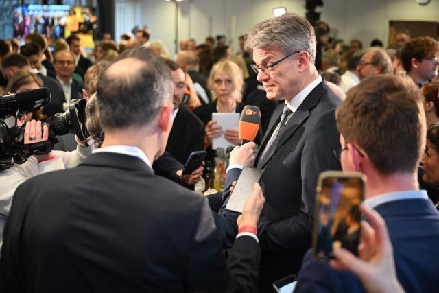 German Transport Minister Patrick Schnieder (C), brother of the conservative CDU party's top candidate for state elections in Rhineland-Palatinate Gordon Schnieder (not in picture), gives an interview on March 22, 2026 at the regional parliament in Mainz, southwestern Germany, as first exit polls of Rhineland-Palatinate's state elections are being released. German Chancellor Friedrich Merz's conservative CDU party ousted the centre-left Social Democratic Party on Sunday in a closely watched state election in which the far right also made big gains, according to exit polls. The CDU took around 30 percent of the vote to win the western state of Rhineland-Palatinate away from the SPD after 35 years, while the far-right Alternative for Germany party (AfD) looked set for a record score in western Germany, with around 20 percent, according to two public TV networks' exit polls. (Photo by DANIEL PETER / AFP)