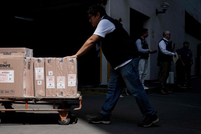 A worker from the ONPE (National Office of Electoral Processes) carries electoral material at the Ministry of Foreign Affairs, to then be sent to voters living abroad, in Lima on March 22, 2026. Peru will hold presidential elections on April 12, 2026. (Photo by ERNESTO BENAVIDES / AFP)