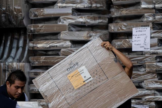 Workers from the ONPE (National Office of Electoral Processes) unload electoral material at the Ministry of Foreign Affairs, to then be sent to voters living abroad, in Lima on March 22, 2026. Peru will hold presidential elections on April 12, 2026. (Photo by ERNESTO BENAVIDES / AFP)