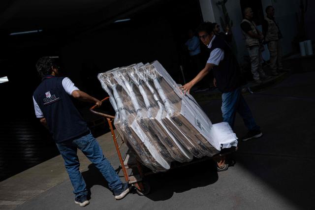 Workers from the ONPE (National Office of Electoral Processes) unload electoral material at the Ministry of Foreign Affairs, to then be sent to voters living abroad, in Lima on March 22, 2026. Peru will hold presidential elections on April 12, 2026. (Photo by ERNESTO BENAVIDES / AFP)