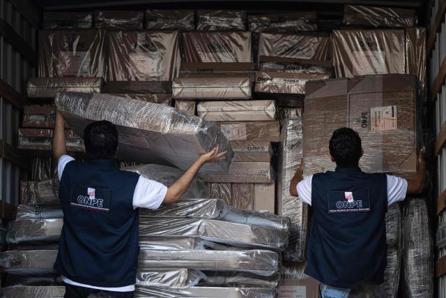 Workers from the ONPE (National Office of Electoral Processes) unload electoral material at the Ministry of Foreign Affairs, to then be sent to voters living abroad, in Lima on March 22, 2026. Peru will hold presidential elections on April 12, 2026. (Photo by ERNESTO BENAVIDES / AFP)