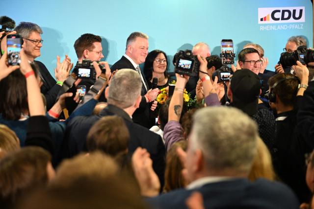 The conservative CDU party's top candidate for state elections in Rhineland-Palatinate Gordon Schnieder (C) arrives to address supporters on March 22, 2026 at the regional parliament in Mainz, southwestern Germany, as first exit polls of Rhineland-Palatinate's state elections are being released. German Chancellor Friedrich Merz's conservative CDU party ousted the centre-left Social Democratic Party on Sunday in a closely watched state election in which the far right also made big gains, according to exit polls. The CDU took around 30 percent of the vote to win the western state of Rhineland-Palatinate away from the SPD after 35 years, while the far-right Alternative for Germany party (AfD) looked set for a record score in western Germany, with around 20 percent, according to two public TV networks' exit polls. (Photo by DANIEL PETER / AFP)