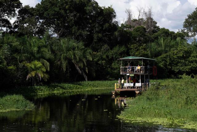 Tourists navegate the Santo Domingo, a tributary of the Miranda river at the Fazenda San Francisco at the Pantanal, a key region along birds' migratory routes in the Americas, in the municipality of Miranda in Mato Grosso do Sul state, Brazil on March 20, 2026. (Photo by Pablo PORCIUNCULA / AFP)