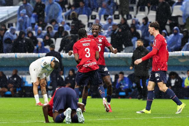 Lille's players celebrate after winning the French L1 football match between Olympique de Marseille (OM) and Lille OSC at the Stade Velodrome in Marseille, southern France on March 22, 2026. (Photo by Pascal POCHARD-CASABIANCA / AFP)