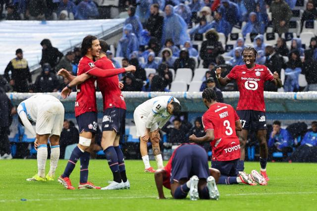 Lille's players celebrate after winning the French L1 football match between Olympique de Marseille (OM) and Lille OSC at the Stade Velodrome in Marseille, southern France on March 22, 2026. (Photo by Pascal POCHARD-CASABIANCA / AFP)