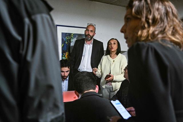 Nimes' City Councillor and left-wing coalition mayoral candidate for Nimes Vincent Bouget (L) and Gard Departmental Coucil Vice-President Amal Couvreur (R) react in the campaign as they await results for the second round of France's 2026 municipal elections in Nimes, southern France on March 22, 2026. (Photo by Gabriel BOUYS / AFP)