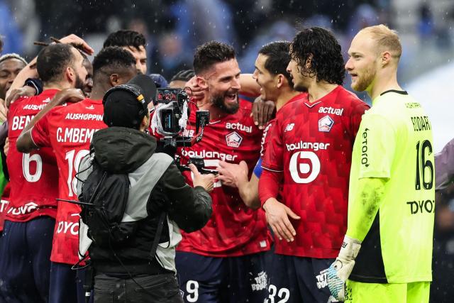 Lille's French forward #09 Olivier Giroud (C) and his teammates celebrate after winning the French L1 football match between Olympique de Marseille (OM) and Lille OSC at the Stade Velodrome in Marseille, southern France on March 22, 2026. (Photo by Pascal POCHARD-CASABIANCA / AFP)