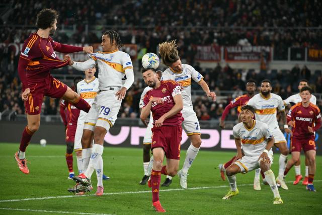 Roma's Italian midfielder #04 Bryan Cristante (C) fights for the ball with Lecce's Italian defender #25 Antonino Gallo during the Italian Serie A football match between AS Roma and Lecce at the Olympic Stadium in Rome on March 22, 2026. (Photo by Alberto PIZZOLI / AFP)