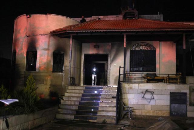A Palestinian man inspects a burnt house beside graffiti of a Jewish Star of David sprayed on the wall following a reported attack by Israeli settlers in the village of Deir al-Hatab, east of Nablus in the occupied West Bank on March 22, 2026. Violence more broadly in the West Bank, which Israel has occupied since 1967, has risen sharply since the October 7, 2023 Hamas attack on Israel triggered the Gaza war. It has continued despite a ceasefire in place since October 10. (Photo by Zain JAAFAR / AFP)