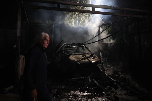 A Palestinian man inspects a burnt-out house and vehicle following a reported attack by Israeli settlers in the village of Deir al-Hatab, east of Nablus in the occupied West Bank on March 22, 2026. Violence more broadly in the West Bank, which Israel has occupied since 1967, has risen sharply since the October 7, 2023 Hamas attack on Israel triggered the Gaza war. It has continued despite a ceasefire in place since October 10. (Photo by Zain JAAFAR / AFP)