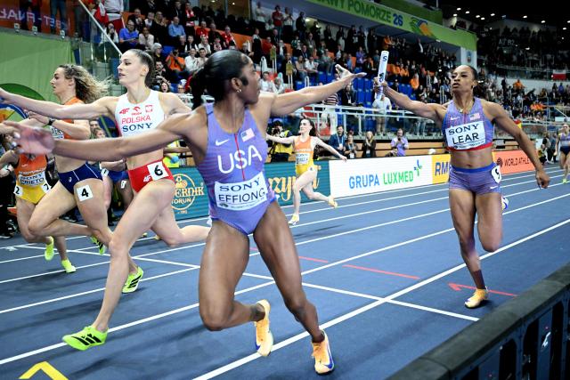 USA's Bailey Lear (R) passes the baton to USA's Rosey Effiong (L) during the women's final 4x400 metres relay event during the World Athletics Indoor Championships Kujawy Pomorze 2026 in Torun, Poland on March 22, 2026. (Photo by Kirill KUDRYAVTSEV / AFP)