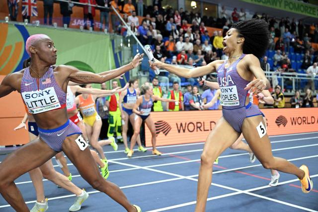 USA's Paris Peoples (R) passes the baton to USA's Shamier Little (L) as they compete in the women's final 4x400 metres relay event during the World Athletics Indoor Championships Kujawy Pomorze 2026 in Torun, Poland on March 22, 2026. (Photo by Kirill KUDRYAVTSEV / AFP)