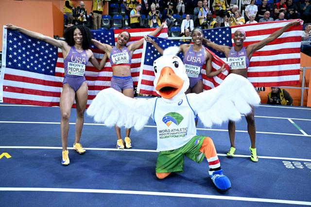 USA's Shamier Little (L), USA's Rosey Effiong, USA's Paris Peoples and USA's Bailey Lear celebrate with mascot Goosisa after the women's final 4x400 metres relay event during the World Athletics Indoor Championships Kujawy Pomorze 2026 in Torun, Poland on March 22, 2026. (Photo by Kirill KUDRYAVTSEV / AFP)