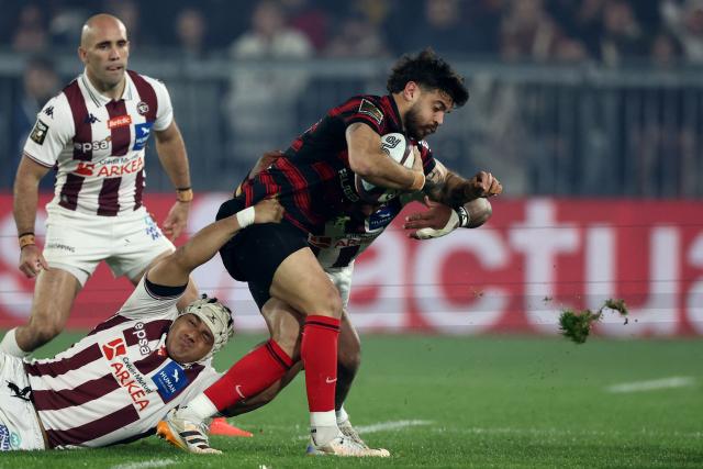 Bordeaux-Begles' French scrum-half Maxime Lucu, Toulouse's French fly-half Romain Ntamack (R) is tackled by Bordeaux-Begles' French number eight Temo Matiu (L) during the French Top14 rugby union match between Union Bordeaux-Begles (UBB) and Toulouse at the Stade Atlantique Bordeaux Metropole in Bordeaux, south-western France, on March 22, 2026.  (Photo by ROMAIN PERROCHEAU / AFP)
