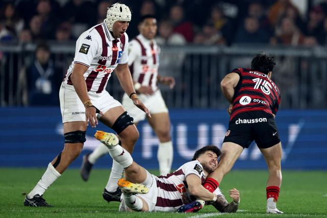 Toulouse' Belgian full back Matias Remue (R) is tackled by Bordeaux' French fly half Matthieu Jalibert (C) during the French Top14 rugby union match between Union Bordeaux-Begles (UBB) and Toulouse at the Stade Atlantique Bordeaux Metropole in Bordeaux, south-western France, on March 22, 2026. (Photo by ROMAIN PERROCHEAU / AFP)
