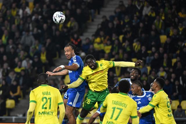 Strasbourg's Ivorian defender #22 Guela Doue (L) heads the ball during the French L1 football match between Nantes and Strasbourg at La Beaujoire stadium in Nantes, western France, on March 22, 2026. (Photo by Sebastien Salom-Gomis / AFP)