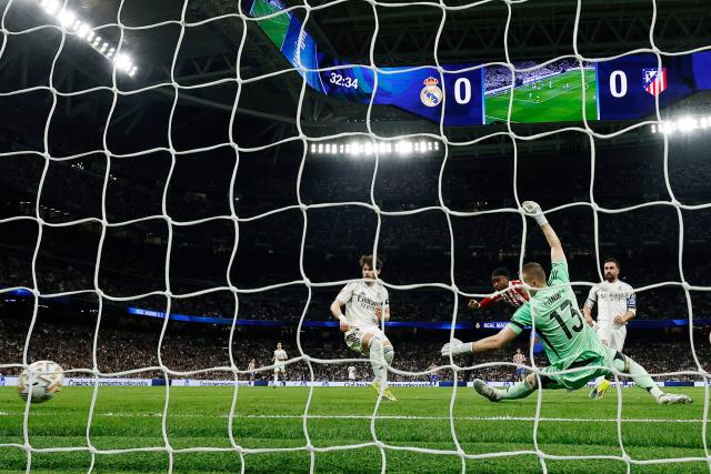 Atletico Madrid's English forward #22 Ademola Lookman (3R) scores yhe opening goal during the Spanish league football match between Real Madrid CF and Club Atletico de Madrid at Santiago Bernabeu Stadium in Madrid on March 22, 2026. (Photo by Oscar DEL POZO / AFP)