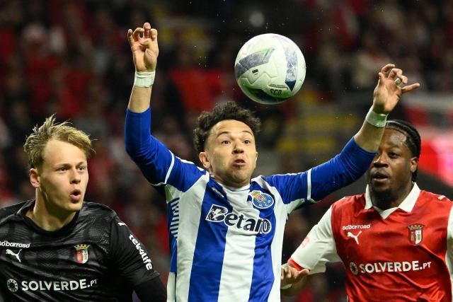 FC Porto's Brazilian forward #11 Pepe (C) watches the ball past Sporting Braga's Czech goalkeeper #01 Lukas Hornicek (L) and German defender #26 Bright Arrey-Mbi during the Portuguese League football match between SC Braga and FC Porto at Municipal stadium of Braga on March 22, 2026. (Photo by Miguel RIOPA / AFP)