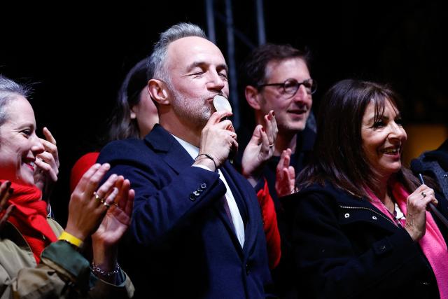 TOPSHOT - Socialistes et Apparentes' MP and Paris' Mayoral candidate Emmanuel Gregoire kisses the key of Paris townhall, accompanied by former Paris' mayor Anne Hidalgo (R) after his victory following the announcement of official results of the second round of France's 2026 municipal elections in Paris on March 22, 2026. (Photo by Kenzo TRIBOUILLARD / AFP)