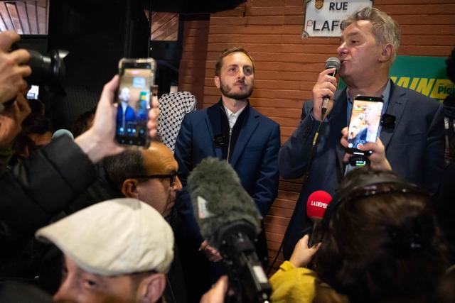 France's left-wing party La France Insoumise (LFI) MP and Toulouse's mayoral candidate François Piquemal (C) listens as Francois Briancon (R) adresses journalists and supporters following the announcement of his defeat after the second round of France's 2026 municipal elections in Toulouse, southwestern France, on March 22, 2026. (Photo by Lionel BONAVENTURE / AFP)