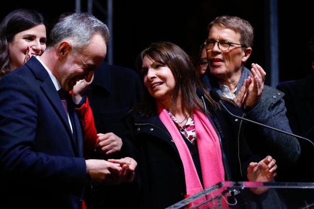 Former Paris' mayor Anne Hidalgo (C) delivers the key of Paris to Socialistes et Apparentes' MP and Paris' Mayoral candidate Emmanuel Gregoire as he celebrates his victory following the announcement of official results of the second round of France's 2026 municipal elections at Paris townhall in Paris on March 22, 2026. (Photo by Kenzo TRIBOUILLARD / AFP)
