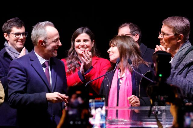 Socialist Party (PS) Member of Parliament and left wing Paris mayoral candidate Emmanuel Gregoire (L) and  Paris outgoing Mayor Anne Hidalgo (R) react during a gathering following the second round of France's 2026 municipal elections in Paris on March 22, 2026. Gregoire was elected Paris mayor in the French capital's municipal elections. (Photo by GEOFFROY VAN DER HASSELT / AFP)
