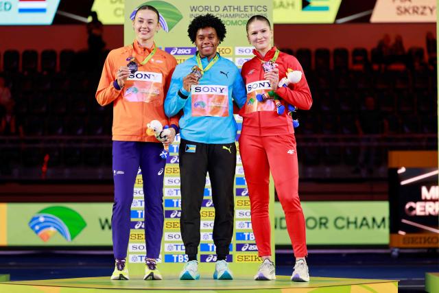 Silver medallist Netherlands' Nadine Visser (L), gold medallist Bahamas' Devynne Charlton and bronze medallist Poland's Pia Skrzyszowska celebrate on the podium for the women's 60m hurdles event during the World Athletics Indoor Championships Kujawy Pomorze 2026 in Torun, Poland on March 22, 2026. (Photo by Wojtek RADWANSKI / AFP)
