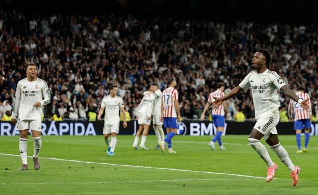 Real Madrid's Brazilian forward #07 Vinicius Junior (R) celebrates scoring his team's third goal during the Spanish league football match between Real Madrid CF and Club Atletico de Madrid at Santiago Bernabeu Stadium in Madrid on March 22, 2026. (Photo by Oscar DEL POZO / AFP)