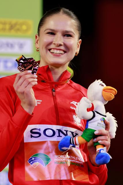 Bronze medallist Poland's Pia Skrzyszowska celebrates on the podium for the women's 60m hurdles event during the World Athletics Indoor Championships Kujawy Pomorze 2026 in Torun, Poland on March 22, 2026. (Photo by Wojtek RADWANSKI / AFP)