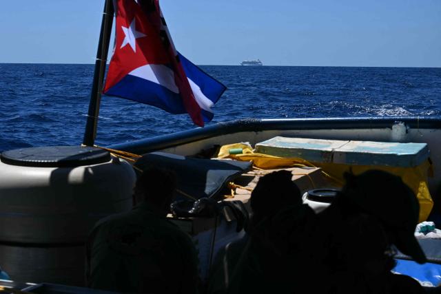 A cruise is pictured from a boat part of the Convoy with 30 tons of humanitarian aid bound for Cuba, organized by left-wing activists from several countries in the Americas and Europe, in the Caribbean Sea on March 22, 2026. (Photo by YURI CORTEZ / AFP)