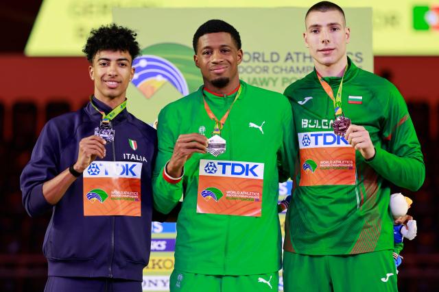Silver medallist Italy's Mattia Furlani (L), gold medallist Portugal's Gerson Balde and bronze medallist Bulgaria's Bozhidar Saraboyukov celebrate on the podium for the men's long jump event during the World Athletics Indoor Championships Kujawy Pomorze 2026 in Torun, Poland on March 22, 2026. (Photo by Wojtek RADWANSKI / AFP)